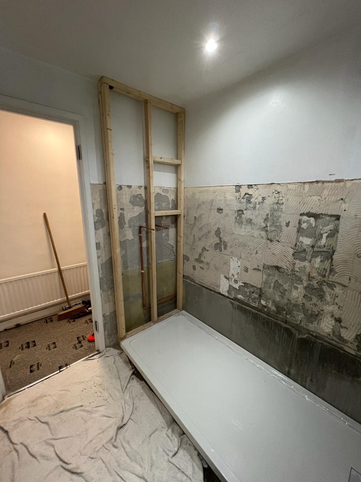 Bathroom renovation work in progress with exposed walls and first-fix plumbing