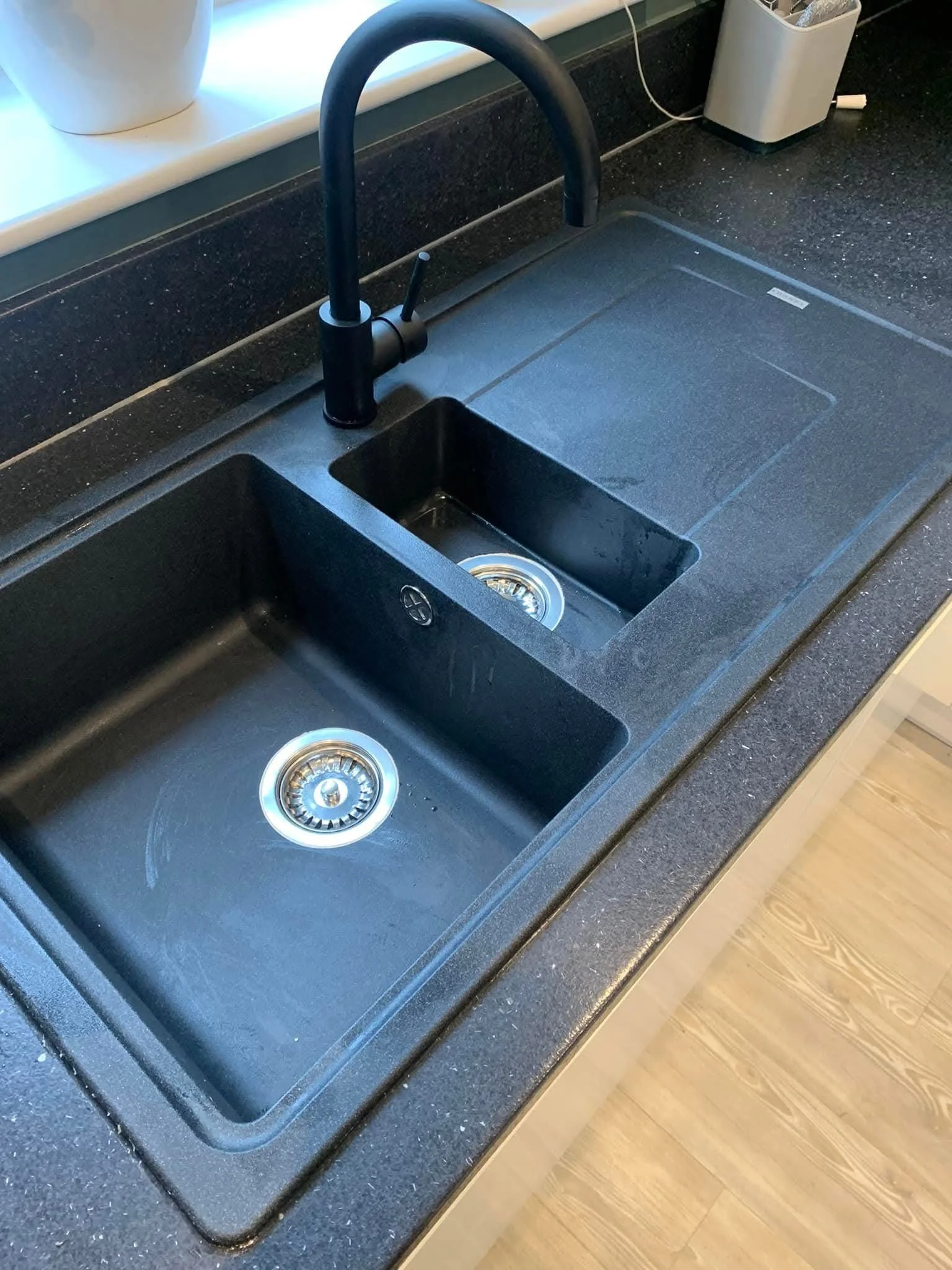 Black kitchen sink with modern black tap