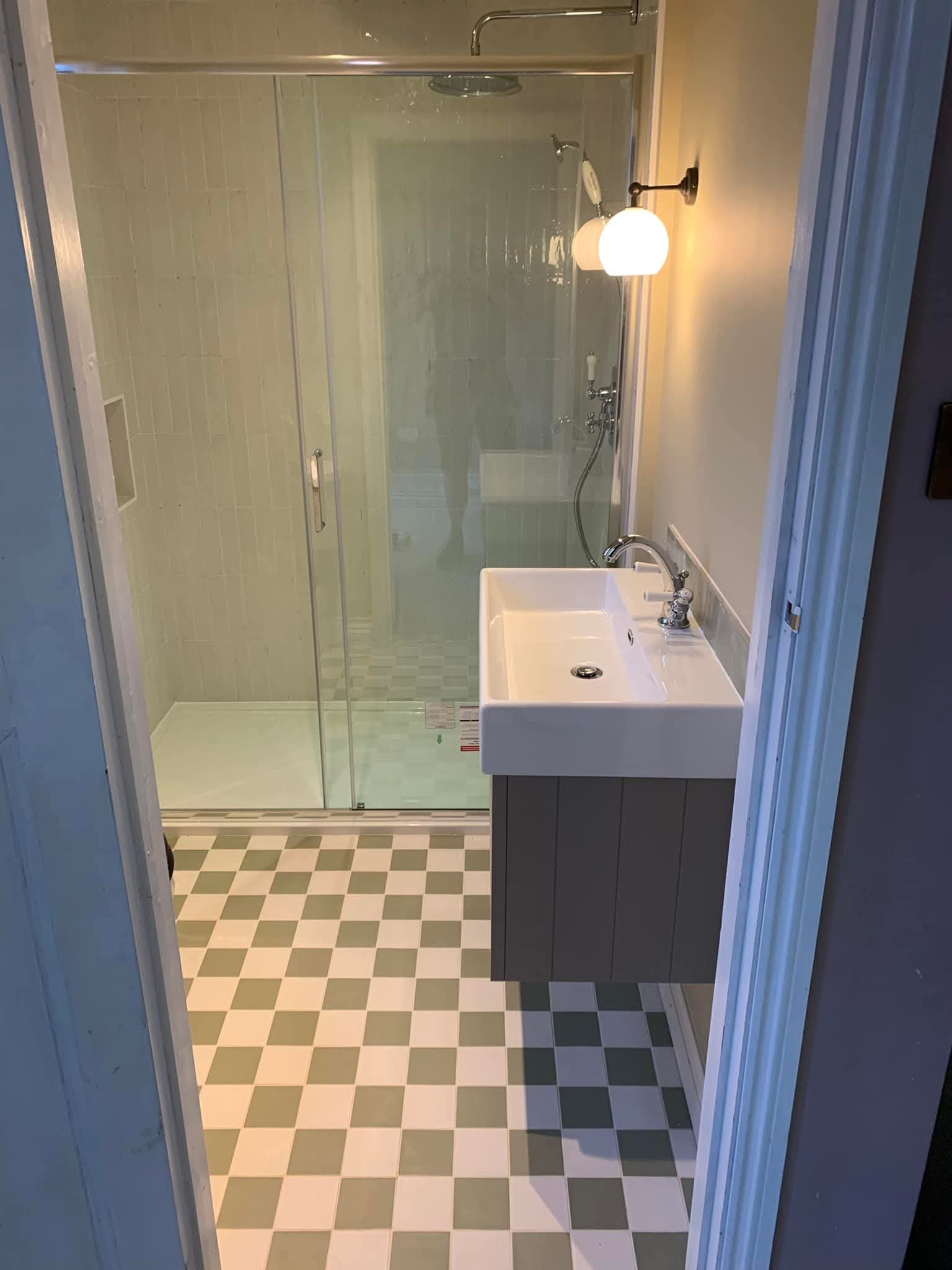 Compact bathroom with glass shower enclosure and fitted sink