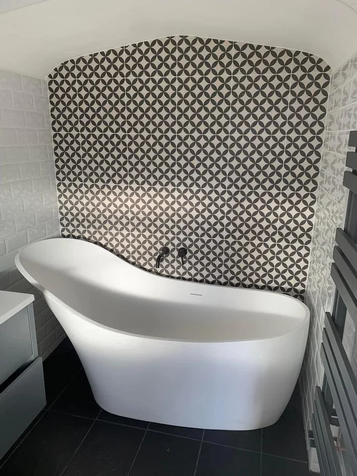 Freestanding bath set against a patterned feature wall