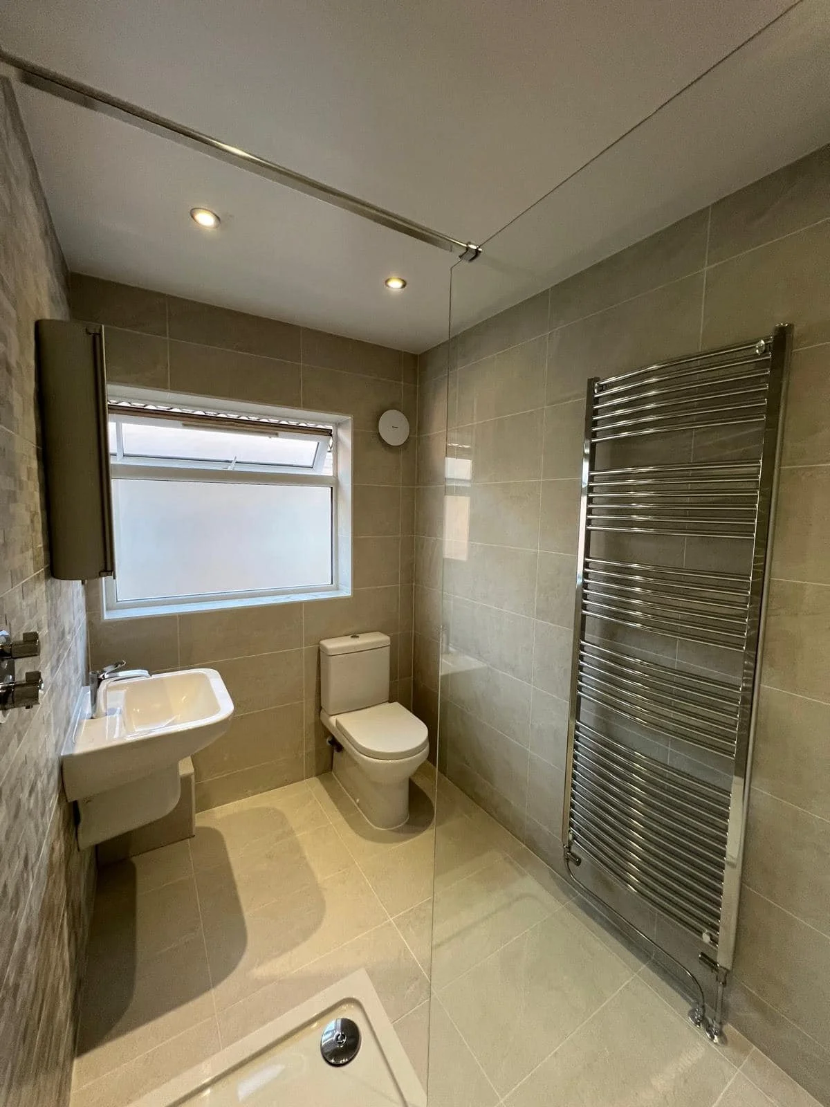 Neutral bathroom with toilet, basin and heated towel radiator